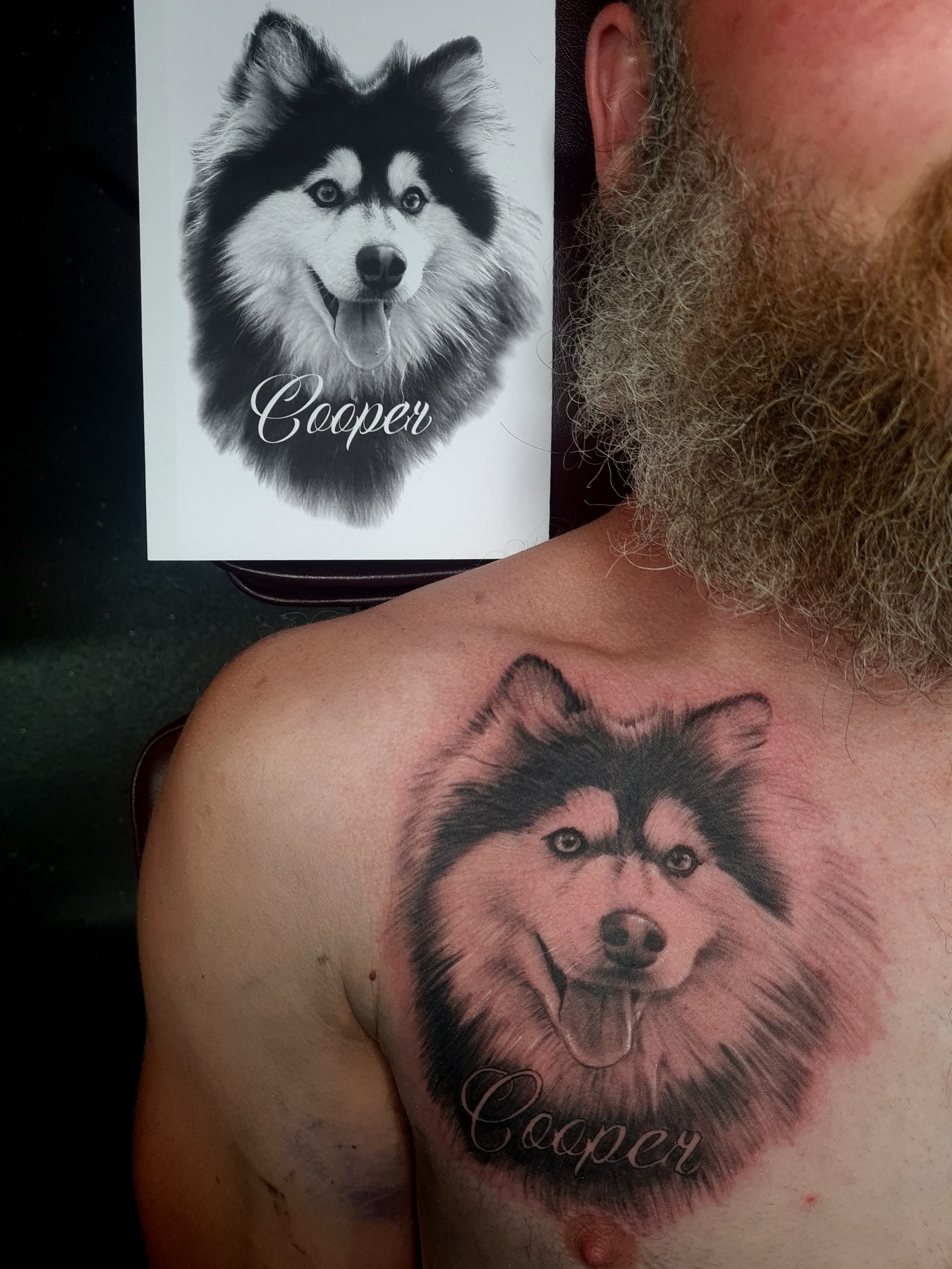 Realistic black and grey tattoo of a dog named Cooper on chest.