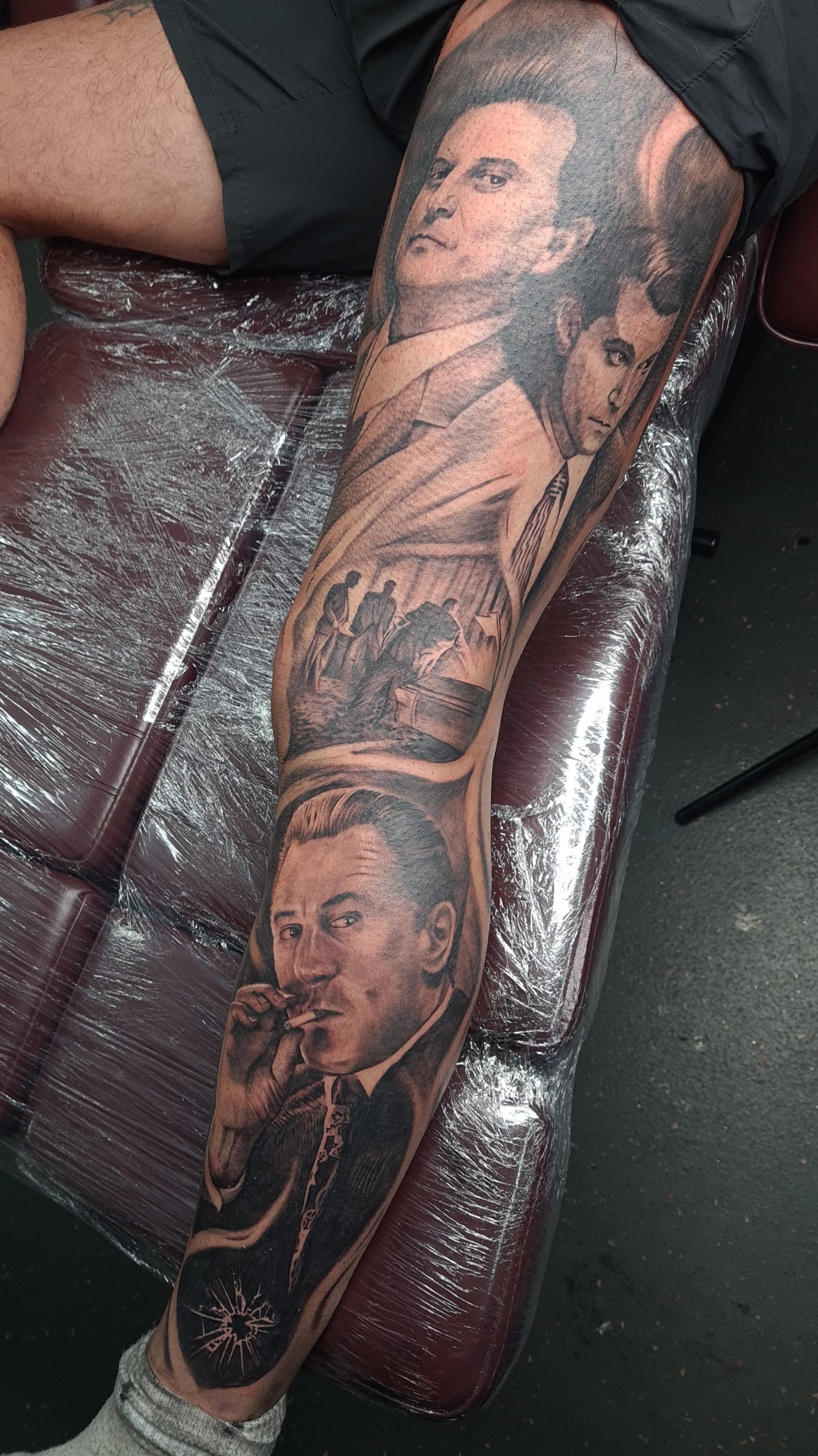 Black and grey realism leg sleeve tattoo depicting Goodfellas film characters and a burial scene
