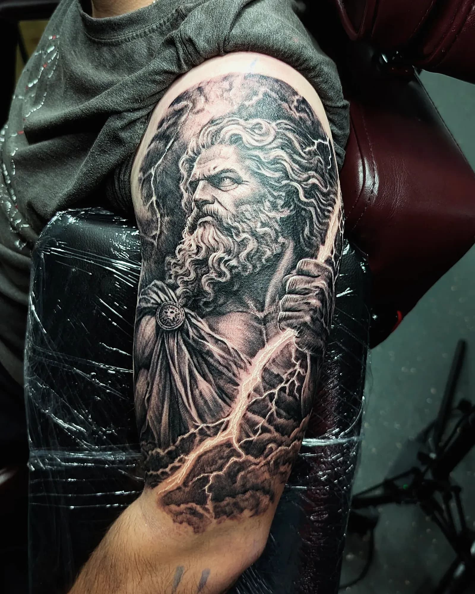 Black and grey realism tattoo of Greek Mythology on the bicep