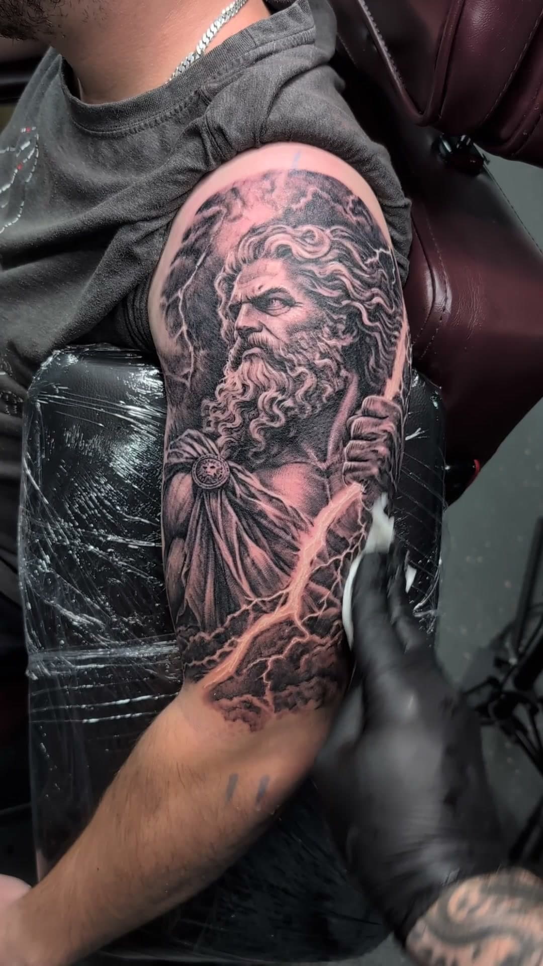 Zeus with lightning bolt upper arm tattoo, stencil to reveal — cover photo